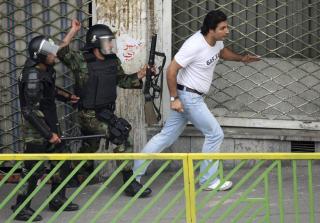 SL�R L�S: En politimann l�fter armen for � sl� en reformtilhenger. Foto: REUTERS/Stringer/SCANPIX