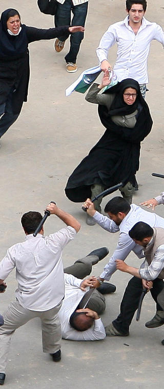 BANKET OPP: Sivilkledde sikkerhetsstyrker sl�r en demonstrant i Teheran med k�ller. Foto: SCANPIX/AP Photo