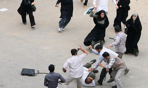 REAGERER HARDT:  Iranske myndigheter sl�r hardt ned p� valgmotstanden. Her f�r en av Mir Hossein Mousavis tilhengere banke av myndighetens sikkerhetsstyrker, mens andre tilhengere l�per til for � hjelpe ham. Foto: Ap Photo