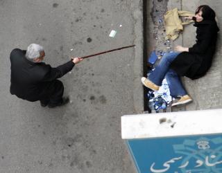 AMPERT: En mann truer en kvinne med stokk. Foto: REUTERS/Stringer/Scanpix