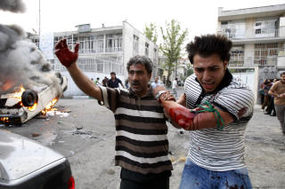 SKADD: En demonstrant hjelpes vekk etter � ha blitt skadd i demonstrasjoner i Teheran. Minst 12 er drept i Iran. Foto: AP photo/Vahid Salemi/Scanpix
