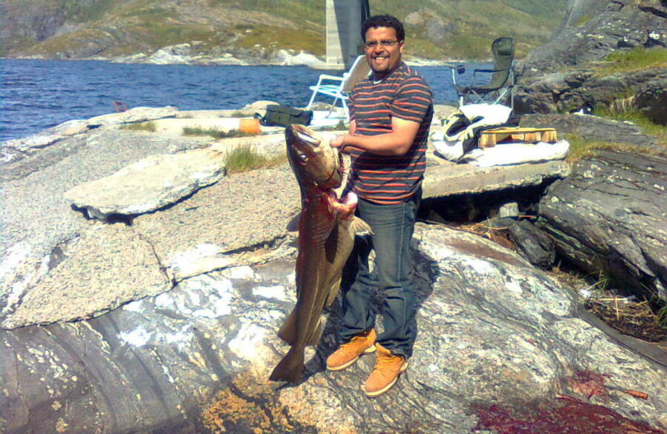 STORFISKER: Kamal fra Yemen hadde aldri holdt i ei fiskestang f�r han tirsdag ble med til Mj�sundet. Der halte han i land denne stortorsken p� nesten 21 kilo. Foto: Per R�rvik