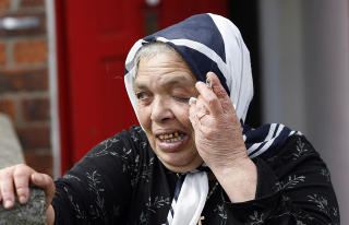 BELFAST: En rumensk romkvinne utenfor sitt hus i Belfast. Mer enn 100 rom flyktet fra hjemmene sine tidligere denne uken, etter en serie med brannbomber og trusler fra lokale gjenger. (Foto: Peter Morrison/Scanpix)