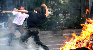 VOLD: En ung mann kaster stein mot politiet i Teheran. Foto: TOPSHOTS/AFP PHOTO/STRINGER/Scanpix