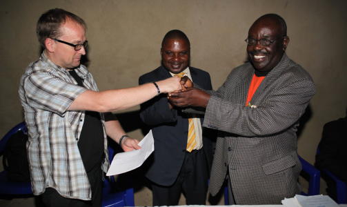 H�NDTRYKK: Sluttdokumentet fra konferansen i Kiwandja overleveres Rune Edvardsen. P� bildet st�r den lokale koordinatoren professor Kabutu Biyagare til h�yre, og r�dgiver for president Kabila, Roger Kibasomba i midten. Foto: Geir Ingar Egeland/Troens Bevis