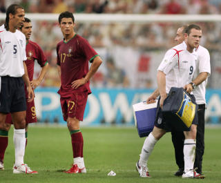 English forward Wayne Rooney (R) leaves the pitch after his red card next to Portuguese forward Cristiano Ronaldo (C) during the World Cup 2006 quarter final football game England vs. Portugal, 01 July 2006 at Gelsenkirchen stadium. AFP PHOTO / ADRIAN DENNIS