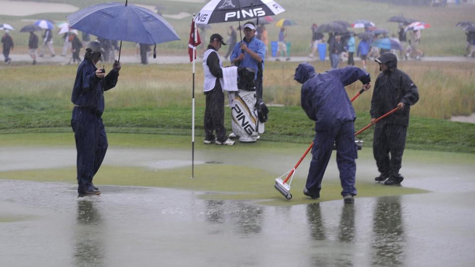 REGNER BORT: Engelske Lee Westwood kan lite annet gj�re enn � se banemannskapene p� The Bethpage Black Course fors�ke � fjerne enorme mengder med overvann p� greenen under �rets US Open, som er i ferd med � regne bort.Foto: SCANPIX/EPA/ANDREW GOMBERT