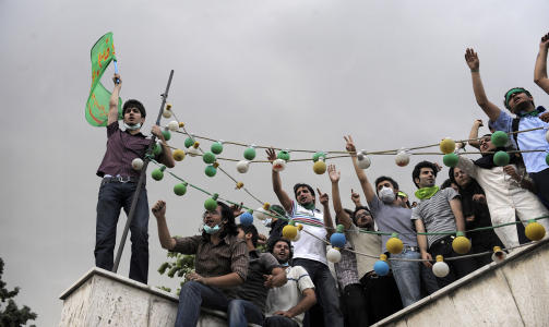 OPP P� TAKENE:  Tilhengere av Mir Hossein Mousavi roper slagord fra taket til studenthuset der de bor. Foto:  AFP PHOTO/OLIVIER LABAN-MATTEI