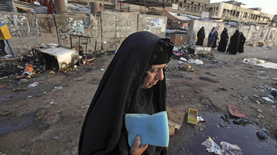 A woman is seen at the site of a bombing in the main Shiite district in Baghdad, Iraq, Thursday, June 25, 2009. A bomb ripped through a crowded market on Wednesday, less than a week before a deadline for U.S. combat troops to leave Iraq's urban areas. (AP Photo/Karim Kadim)