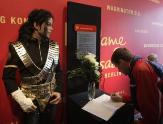 FANSEN S�RGER Her skriver en bes�kende i kondolanseboka ved siden av voksfiguren av Michael Jackson i Madame Tussauds i Berlin. Foto: REUTERS/Tobias Schwarz