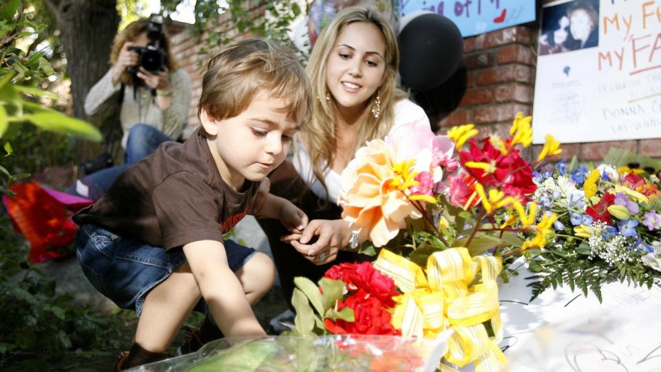 MINNES JACKSON: En ung gutt og hans mor legger ned blomster utenfor Jackson-familiens hjem i Encino i California. Familien har f�tt klarsignal til � begynne planleggingen av begravelsen. Foto: REUTERS/Mario Anzuoni/Scanpix