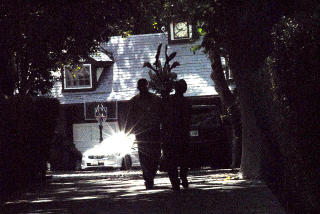 BAK PORTEN og forbi en lang all� med tr�r ligger Jackson-familiens hus. Her entrer to personer med blomster. Foto: GEIR BARSTEIN/DAGBLADET