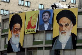 DE MEKTIGE LEDERNE: St�ttespillerne til  Mahmoud Ahmadinejad har hengt opp en plakat av ham mellom ayatollah Ali Khamenei (til venstre) og lederen for revolusjonen i 1979, n� avd�de ayatollah Ruhollah Khomeini. Foto: EPA/ABEDIN TAHERKENAREH