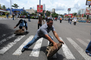 BARIKADER: Demonstranter brukte stein til � sette opp barikader i n�rheten av presidentpalasset i Tegucigalpa. Foto: AFP/ORLANDO SIERRA