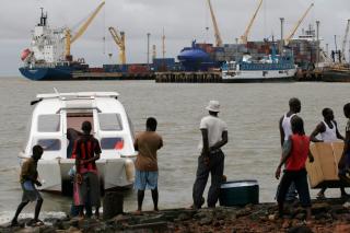 N�KKELEN TIL EUROPA: Latinamerikanske smuglere frakter kokain i sm�fly eller b�ter til Guinea-Bassau. Derfra sendes mesteparten til Europa. Her p� bildet st�r innbyggerne rundt en b�t som vanligvis brukes av smuglere. Foto: Scanpix.