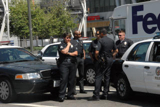 POLITIOPPBUD: Et dusinvis politifolk er p� plass ved sperringene p� Staples Center, men vil ikke kommentere bakgrunnen til at de er der. Foto: Geir Barstein