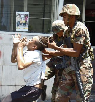HARD BEHANDLING: Her f�r en demonstrant som har vist sin st�tte til Zelaya hard behandling av soldater i  San Pedro Sula. Foto: AFP