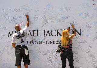 ON THE WALL: En rekke minnesmerker har poppet opp i L.A. etter ikonets plutselige d�d. Her signerer fans en tavle ved Staples Center i sentrum, hvor tirsdagens minnestund finner sted. Foto: GEIR BARSTEIN