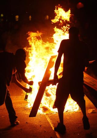 FLAMMER: Br�kmakere satte fyr p� biler og kastet flasker og steiner mot politiet i Hamburg l�rdag. 27 politimenn ble s�ret i oppt�yene. Foto: REUTERS/Christian Charisius / SCANPIX