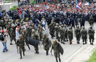 DEMONSTRERER: Et stort oppbud av soldater og demonstranter p� Toncontin-flyplassen i Honduras' hovedstad Tegucigalpa s�ndag kveld lokal tid. Foto: AFP/SCANPIX