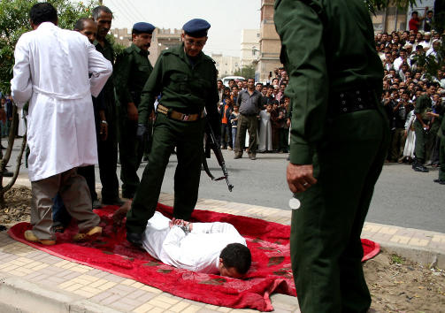INNTAR POSISJON: Politimannen gj�r seg klar til � henrette Yahia al-Raghwa (22). Foto: AFP PHOTO/STR