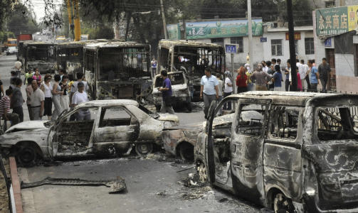 �DELEGGELSER: Biler og bygninger har blitt �delagt i oppt�yene. Foto: XINHUA/AP/SCANPIX