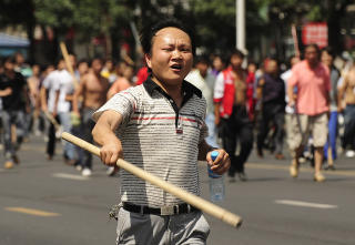 JAGES: En hankineser l�per gjennom gatene med k�lle. Foto: AFP/Peter PARKS/SCANPIX