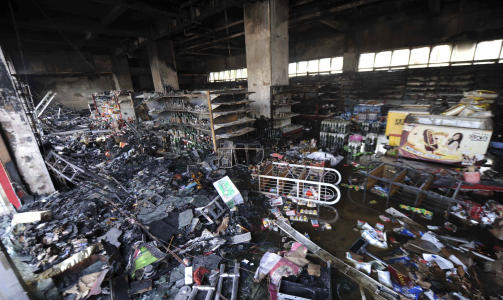 �DELEGGELSER: Et supermarked sees etter oppt�yene s�ndag. Tirsdag skal hankinesere ha hevdet �deleggelsene ved � sl� til mot uigurers butikker. Foto:AP/SCANPIX