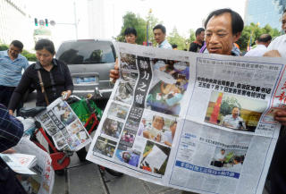 NYTT P� KINESISK:  En han-kineser leser om oppt�yene i hjembyen Urumqi. Foto: KYODO NEWS/AP/SCANPIX.