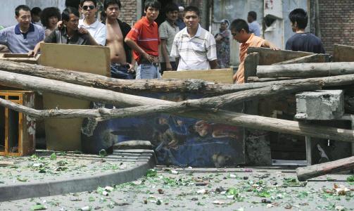  BARRIKADER:  En gruppe uigurer bak en hjemmesnekret barrikade i Urumqi. Foto: KYODO NEWS/AP/SCANPIX.