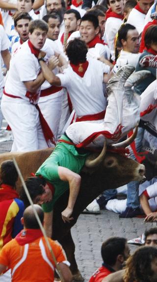 ENORME KREFTER: Oksen Capuchino setter hornene i en deltager. Foto: REUTERS/Susana Vera/Scanpix
