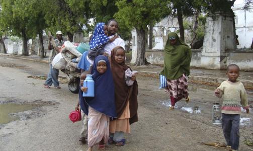 P� FLUKT: Et somalisk barn smiler mens familien flykter fra Mogadishu. Foto: REUTERS