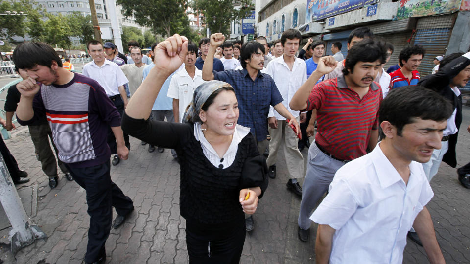 DEMONSTRASJONER: Madina Ahtam (i midten) ledet an i demonstrasjoner i Urumqi p� fredag. Den muslimske minoritetsgruppen uighurene har den siste uken demonstrert mot kinesiske myndigheter. (AP Photo/Eugene Hoshiko)