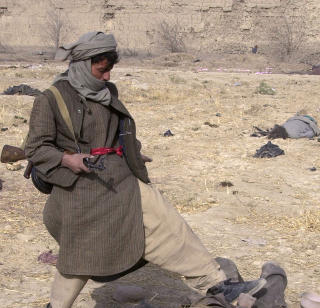 BESKYLDES FOR KRIGSFORBRYTELSER: Nordalliansen skal ha st�tt bak massedrap og massegraver i Afghanistan. Her er en soldat i alliansen avbildet mens han sparker til en d�d Taliban-soldat. Foto: AP Photo/Darko Bandic/Scanpix