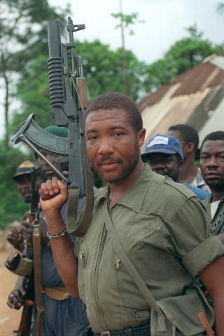 REBELL: I dette bildet fra 1990 holder Charles Taylor Sovjet-riflen AK-47. Han inntok i dag vitneboksen, der han vil gi et vitneutsagn som kommmer til � vare i flere uker. Foto: AFP PHOTO/FILES/PASCAL GUYOT/Scanpix