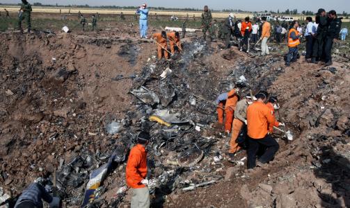 KRATER: Iransk redningsmannskap s�ker i vrakrester. EPA/ABEDIN TAHERKENAREH