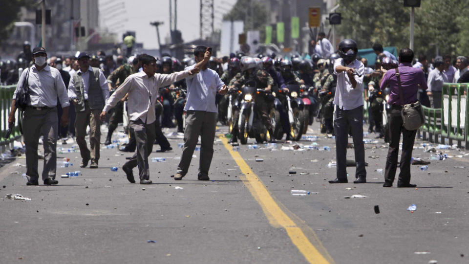 T�REGASS: Dette bildet viser et militsmedlem som retter et t�regassv�pen mot en av demonstrantene utenfor universitetet i Teheran fredag. P� grunn av at mediene ikke har tilgang til Iran, sender nyhetsbyr�ene n� ut en del bilder som er tatt av ulike personer i Iran, og det er derfor ikke bekreftet av dem at bildet er tatt i dag. Foto:  AP/SCANPIX