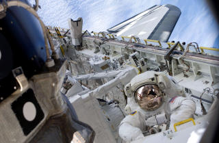 FEM ROMTURER: Astronaut Tim Kopra, er p� den f�rste av fem spaserturer i rommet. Bak sees Endavours losse rigg og lasterom. FOTO: AFP/NASA VIDEO