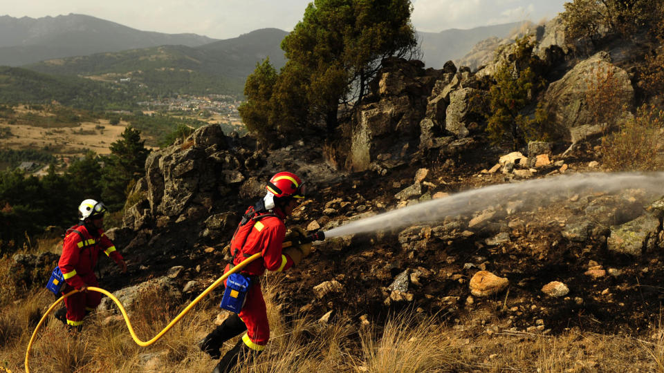 TIL KRIG MOT FLAMMENE: Den spanske milit�re beredskapstroppen UME pr�ver � slokke skogbrannen i Cerro del Castillo n�r byen Collado Mediado, nordvest for Madrid. Rundt 2000 mennesker har m�ttet avekuere byen. Fire brannmenn har blitt drept, mens to har blitt alvorlig skadet i kampene. Foto: AFP PHOTO / PEDRO ARMESTRE / Scanpix