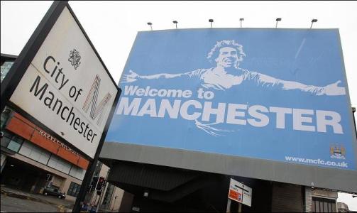 WELCOME TO MANCHESTER:  Manchester City har hengt opp bannere med bilde av Carlos Tevez ved bygrensa til Manchester. Foto: Faksimile The Sun.