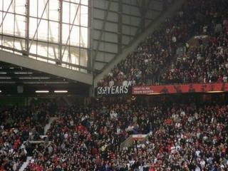 PROVOSERER HUGHES: Mark Hughes mener Manchester City er fullt berettiget til � klistre opp plakater av Carlos Tevez n�r Manchester United har hatt dette banneret hengende oppe p� Old Trafford i �revis for � minne byrivalen om hvor lenge siden det er City vant en pokal av betydning.Faksimile: just-football.com
