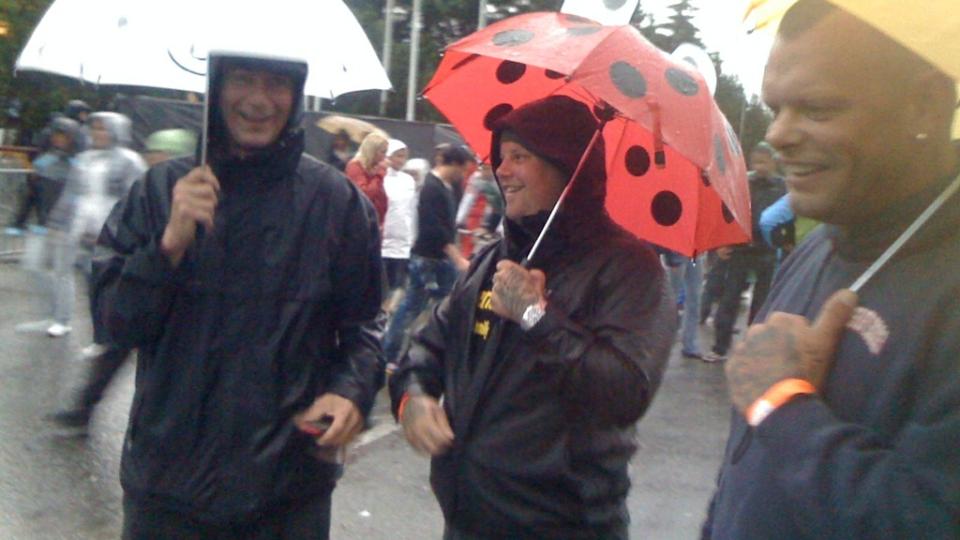  FUKTIG OPPLEVELSE:  Disse konsertgjengerne har forel�pig sikra seg mot regnet med paraplyer. Men dem kan de bare glemme � f� med inn p� selve konsertomr�det. Foto: J�rgen Brynhildsvoll