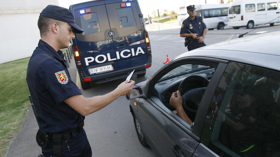 A policeman controls a documents of a driver at a control point at Palma de Mallorca's Airport, on July 31, 2009. Spain went on maximum alert today as ETA marked its 50th anniversary after two bombings this week blamed on the Basque separatist group, including an attack that killed two police officers. AFP PHOTO/ Jaime REINA