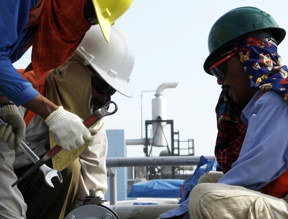ADVARER: Oljearbeidere sjekker en r�rledning ved Exxon Mobils anlegg i Java-provinsen i Indonesia. Det internasjonale energibyr�et advarer mot at en ny oljekrise er i emning. Foto: REUTERS / Beawiharta / SCANPIX