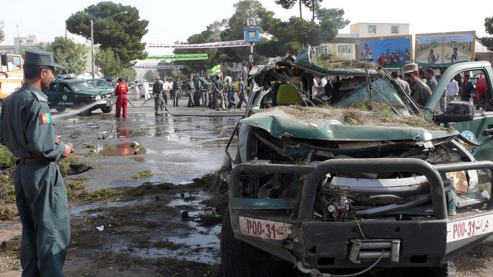 D�DELIG ANGREP: En afghansk politimann ved �stedet for bombe som drepte minst 12 mennesker i Herat i dag. Angrepet bidrar til � forsterke uroen foran valget som avholdes om tre uker. Foto: Scanpix