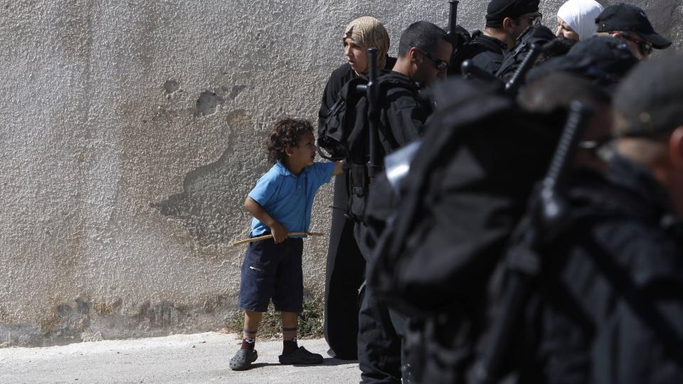 KASTET UT AV HUSET FAMILIEN EIDE I 50 �R: Maysoon al-Rawi st�r sammen med sin fire �r gamle s�nn Adam bak de israelske soldatene som s�ndag kastet dem ut av huset deres i �st-Jerusalem. Norge reagerer p� utkastelsen av to palestinske storfamilier. Foto: REUTERS / Ronen Zvulun / SCANPIX