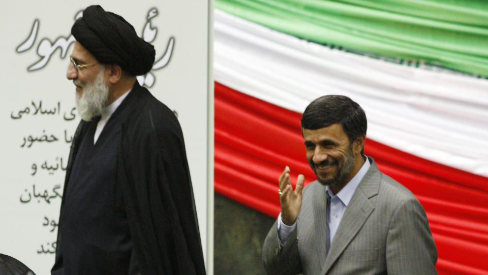 VINKET: Irans president Mahmoud Ahmadinejad vinket da han ankom for � bli tatt i ed. Til venstre g�r ayatollah Mahmoud Hashemi Shahroudi. Flere hundre m�tte opp utenfor parlamentsbygningen for � protestere mot presidenten som mange mener kuppet valget. De ble m�tt av tungt v�pna politi. Ingen uroligheter br�t ut. Foto: AP Photo/Vahid Salemi