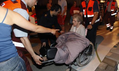 DE SOM VAR V�KNE KOM SEG UT: En eldre kvinne f�r assistanse etter � ha blitt reddet ut av det brennende sykehjemmet. Foto: REUTERS/SCANPIX