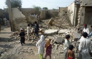 In this photo taken Tuesday, Aug. 4, 2009, Pakistani villagers look at a house belonging to supporters of Pakistani Taliban leader Baitullah Mehsud which was destroyed by authorities in Dera Ismail Khan, Pakistan.  (AP Photo/Ishtiaq Mehsud)
