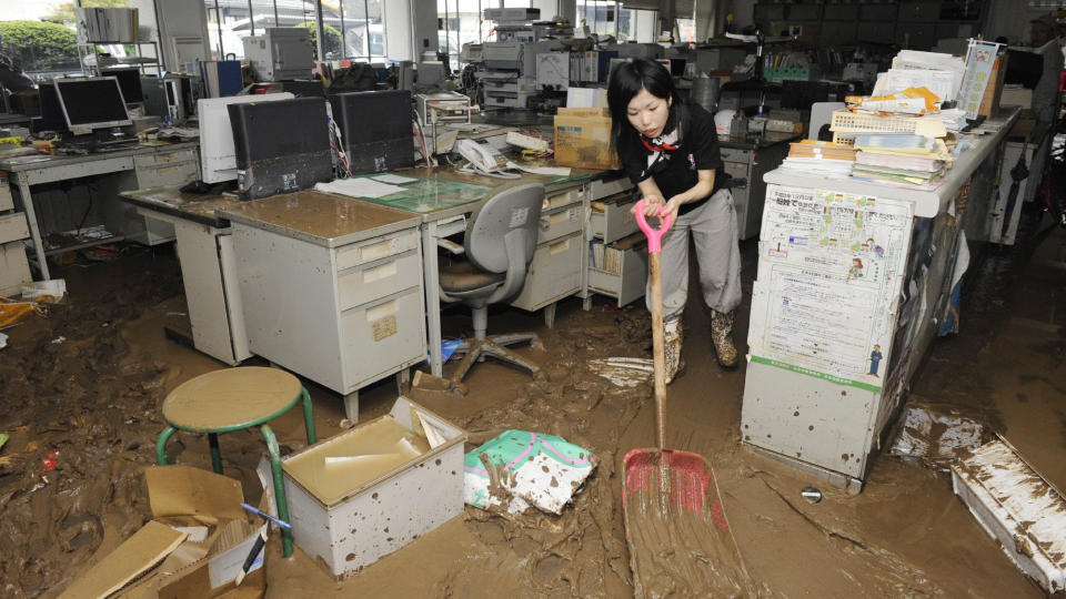 STORMHERJINGER: Minst ni personer d�de som f�lge av jordskred og oversv�mmelser da tyfornen Etau begynte sine herjinger langs Japans vestkyst. Denne kvinnen fors�ker � rydde et kontorlokale i Sayo for leire. Foto: SCANPIX/AP Photo/Kyodo News